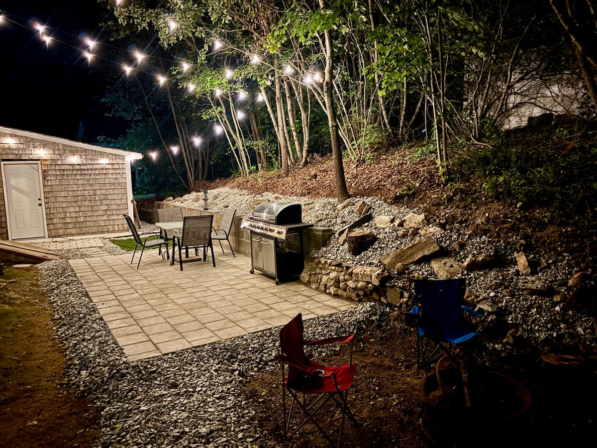 Shared patio with grill, dining, and string lights
